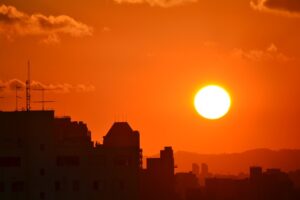 hot sun setting over industrial buildings